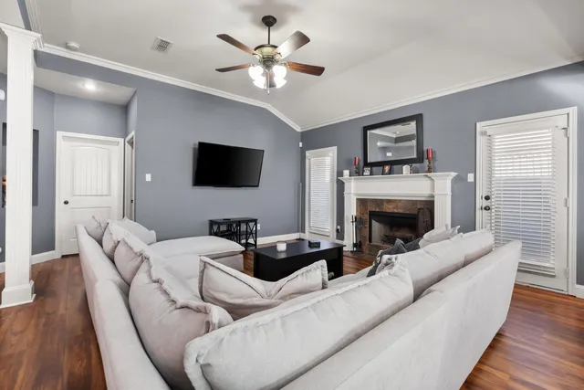 a living room with furniture a fireplace and a flat screen tv
