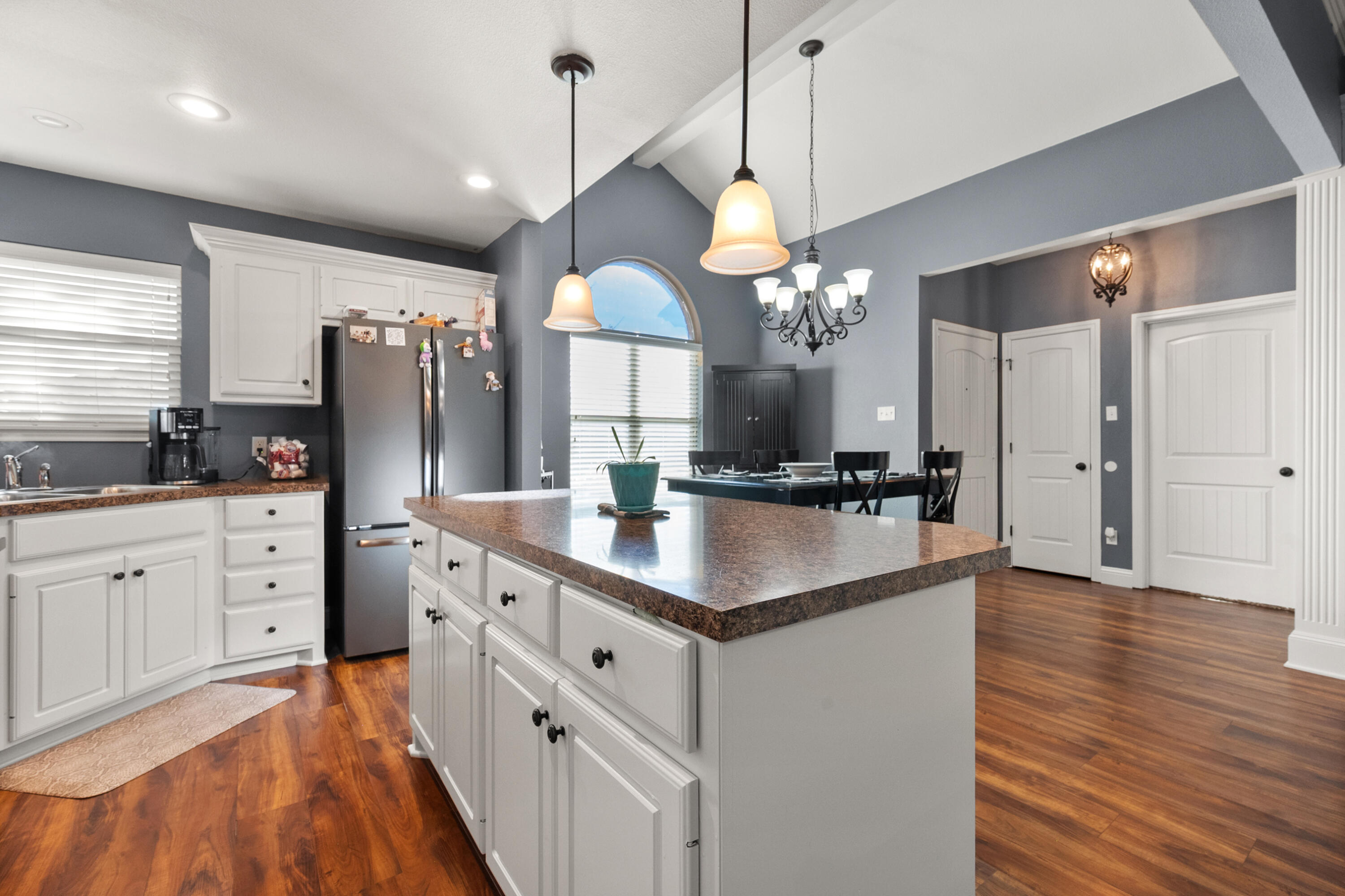 5908 104th Street Lubbock, TX 79424 - Photo 8 of 33 a kitchen with stainless steel appliances kitchen island granite countertop a sink cabinets and wooden floor
