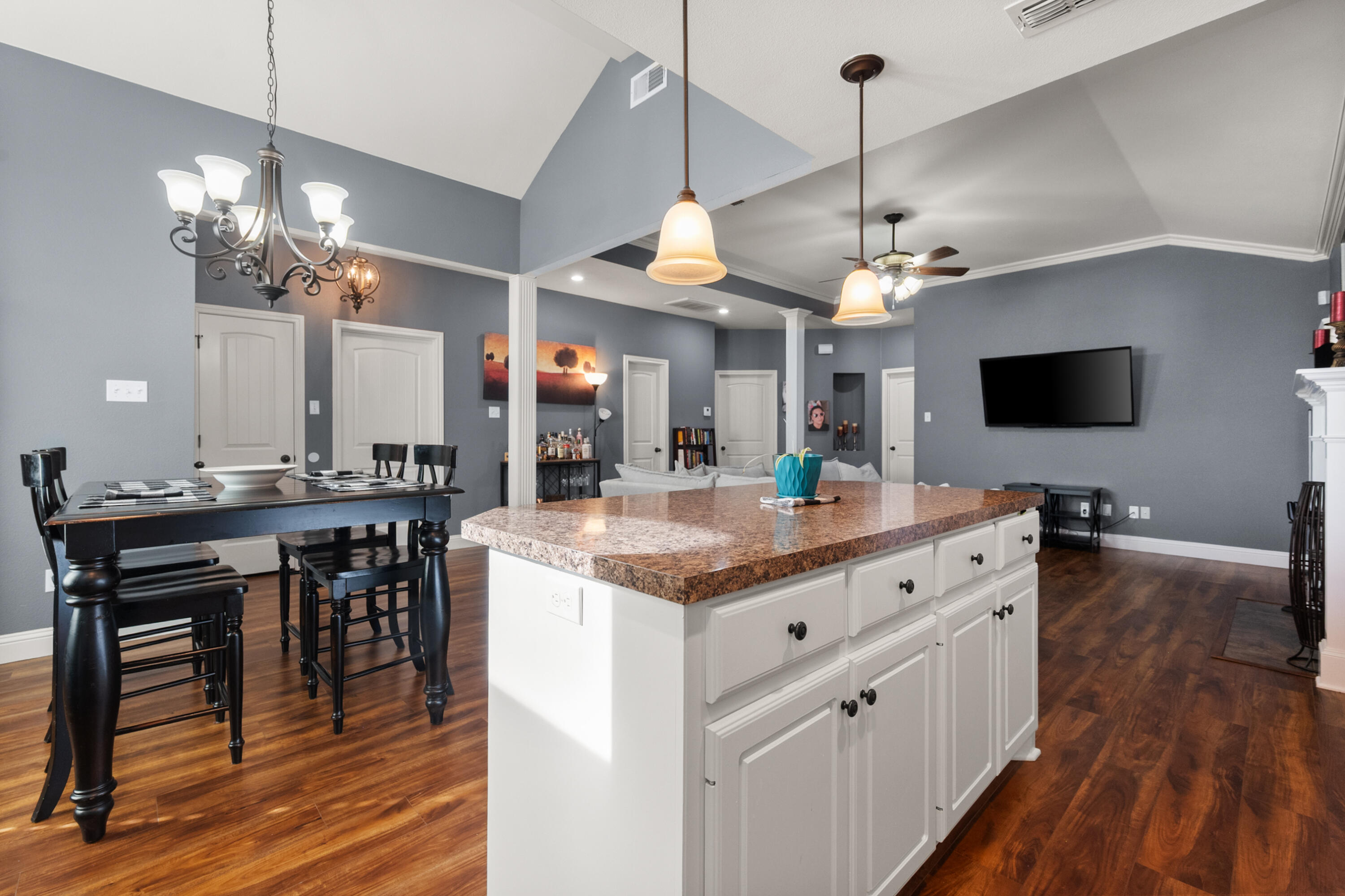 5908 104th Street Lubbock, TX 79424 - Photo 9 of 33 a large kitchen with kitchen island a dining table chairs and a chandelier