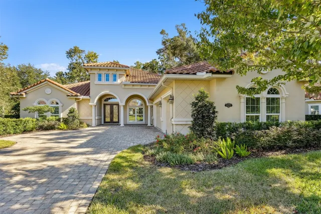 a view of a white house with a yard and plants