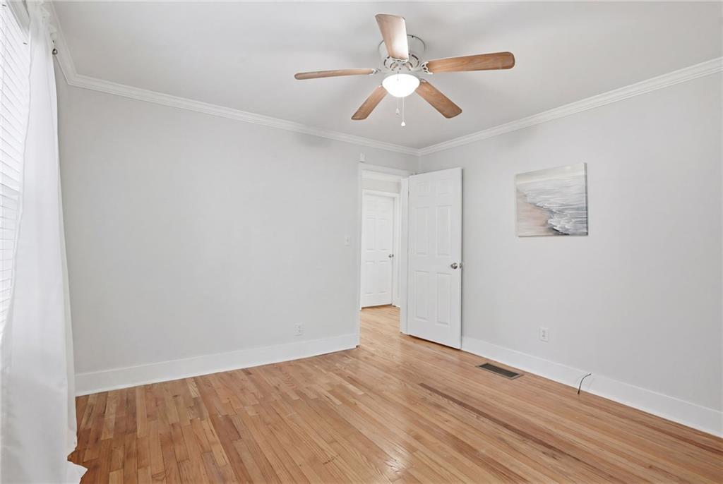1222 Elizabeth Avenue Southwest Atlanta, GA 30310 - Photo 25 of 46 an empty room with wooden floor and ceiling fan