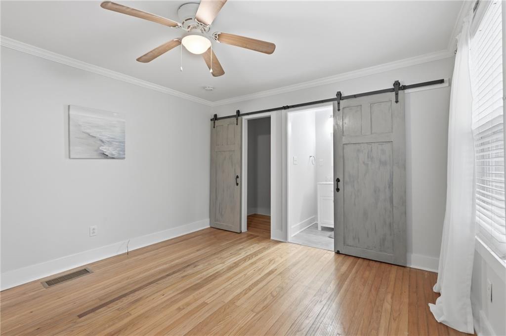1222 Elizabeth Avenue Southwest Atlanta, GA 30310 - Photo 27 of 46 a view of an empty room with wooden floor and a ceiling fan