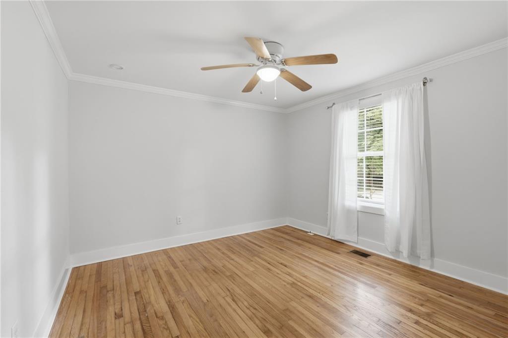 1222 Elizabeth Avenue Southwest Atlanta, GA 30310 - Photo 32 of 46 an empty room with wooden floor fan and windows