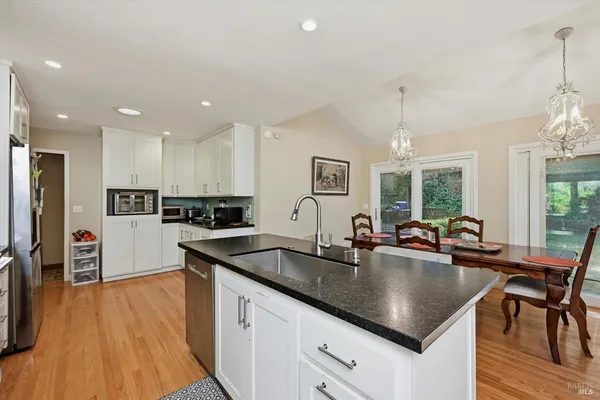 a kitchen with stainless steel appliances granite countertop a sink a stove and refrigerator