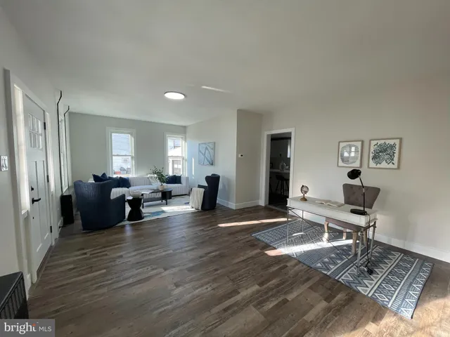 a kitchen with a sink chairs and wooden floor
