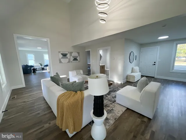 a view of a white house with a big yard and large trees