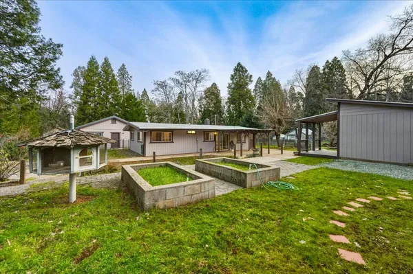 a view of a house with backyard and sitting area