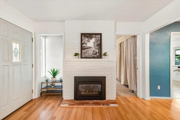 a living room with a fireplace and wooden floor