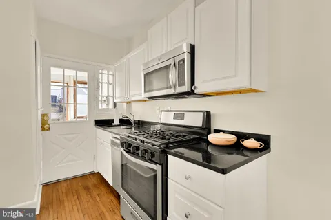 a kitchen with granite countertop a stove and a sink