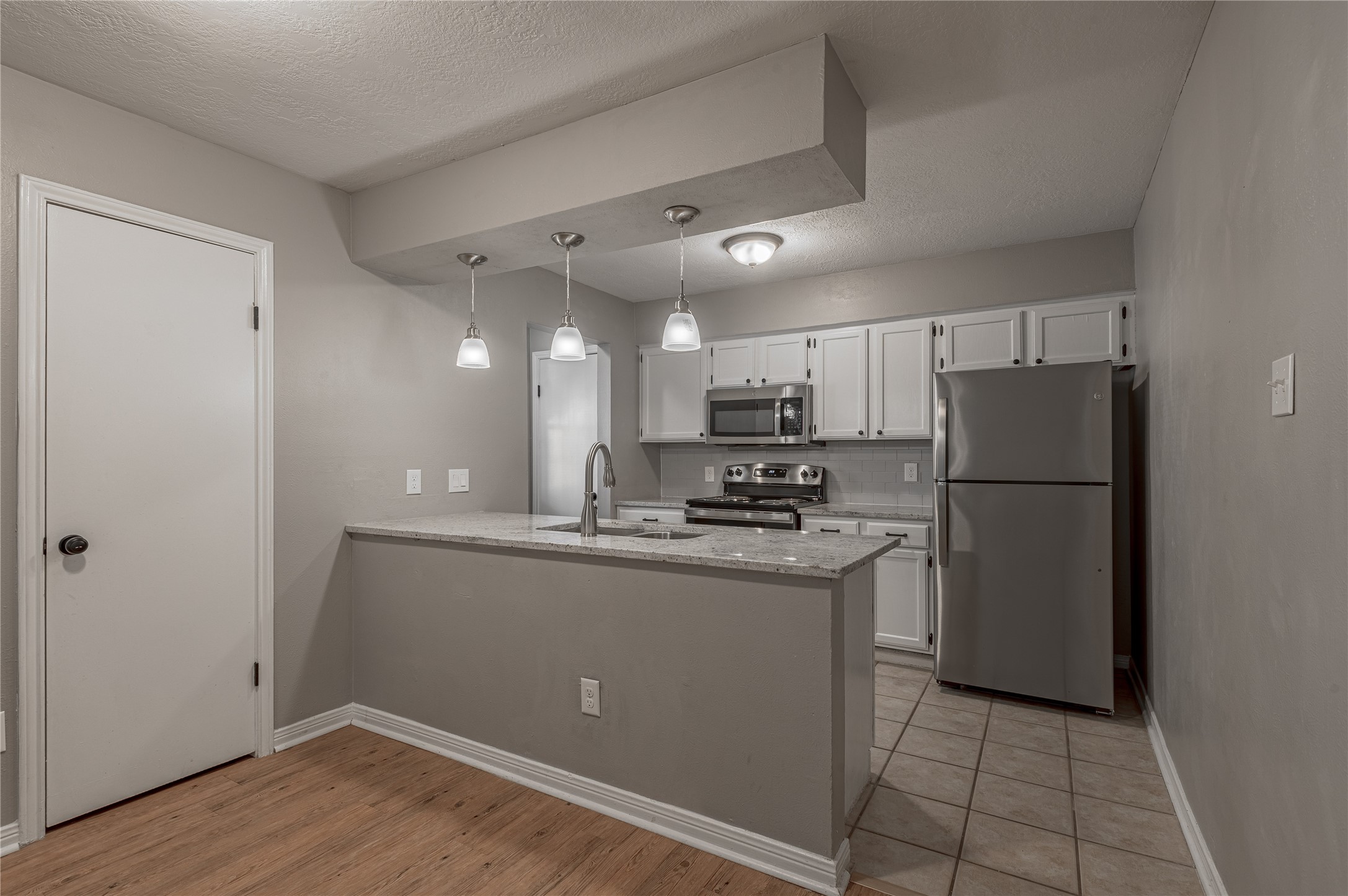 2402 Sycamore Avenue, Unit E2 Huntsville, TX 77340 - Photo 11 of 43 a kitchen with stainless steel appliances granite countertop a refrigerator a sink a stove a microwave and a refrigerator