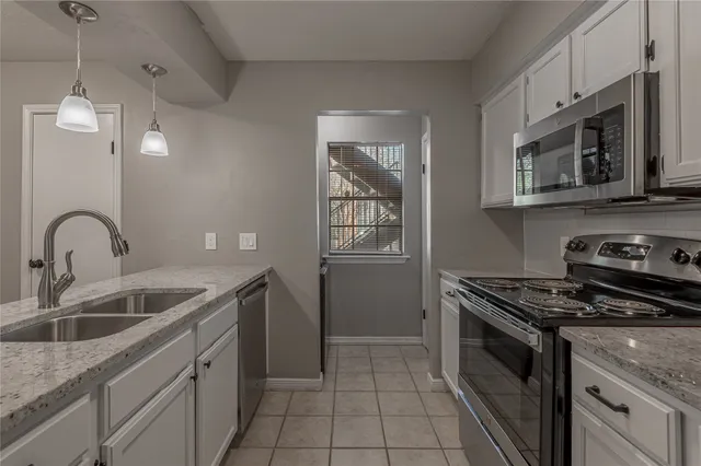 a kitchen with stainless steel appliances granite countertop a sink stove and cabinets
