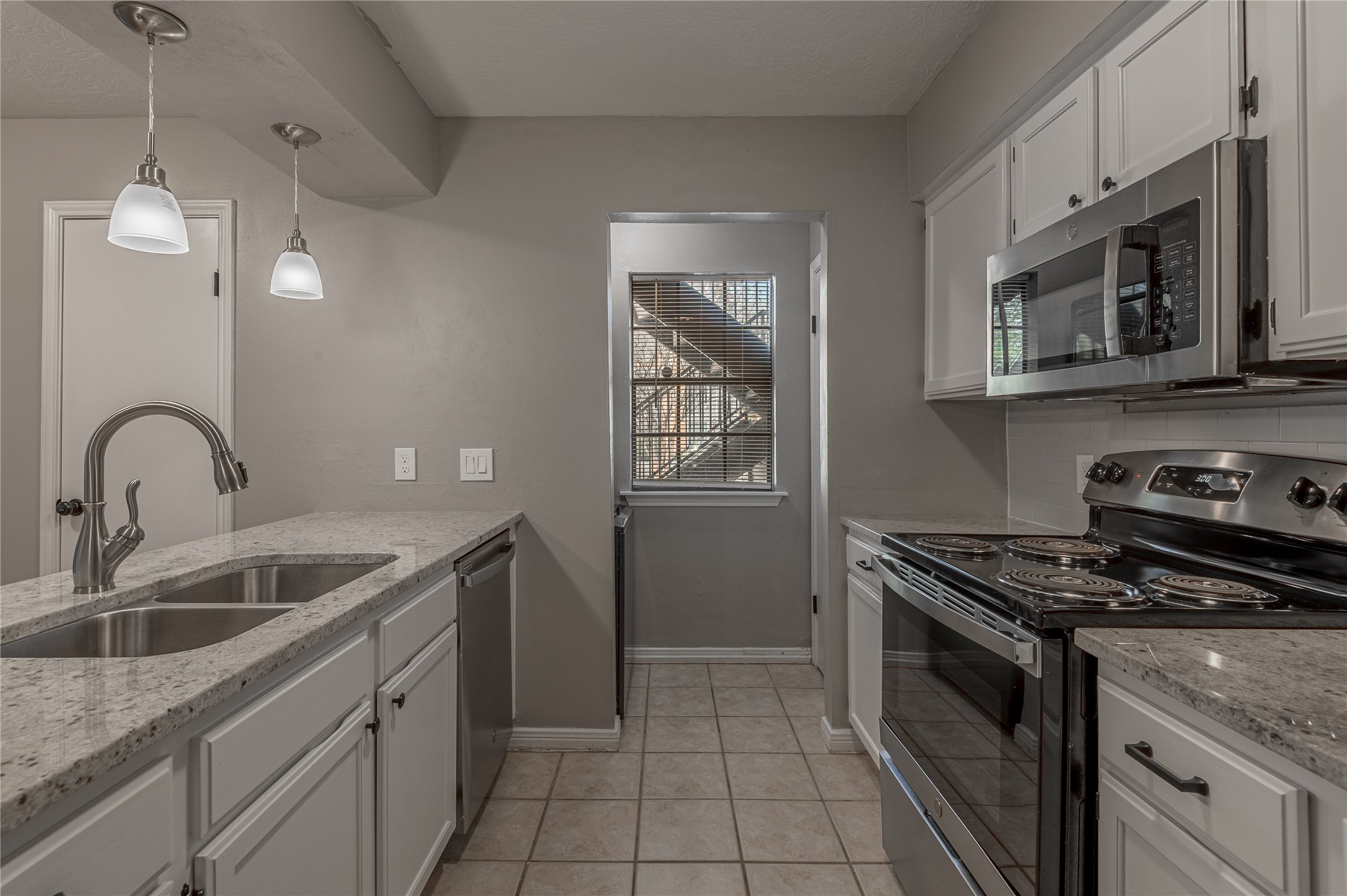 2402 Sycamore Avenue, Unit E2 Huntsville, TX 77340 - Photo 13 of 43 a kitchen with stainless steel appliances granite countertop a sink stove and cabinets