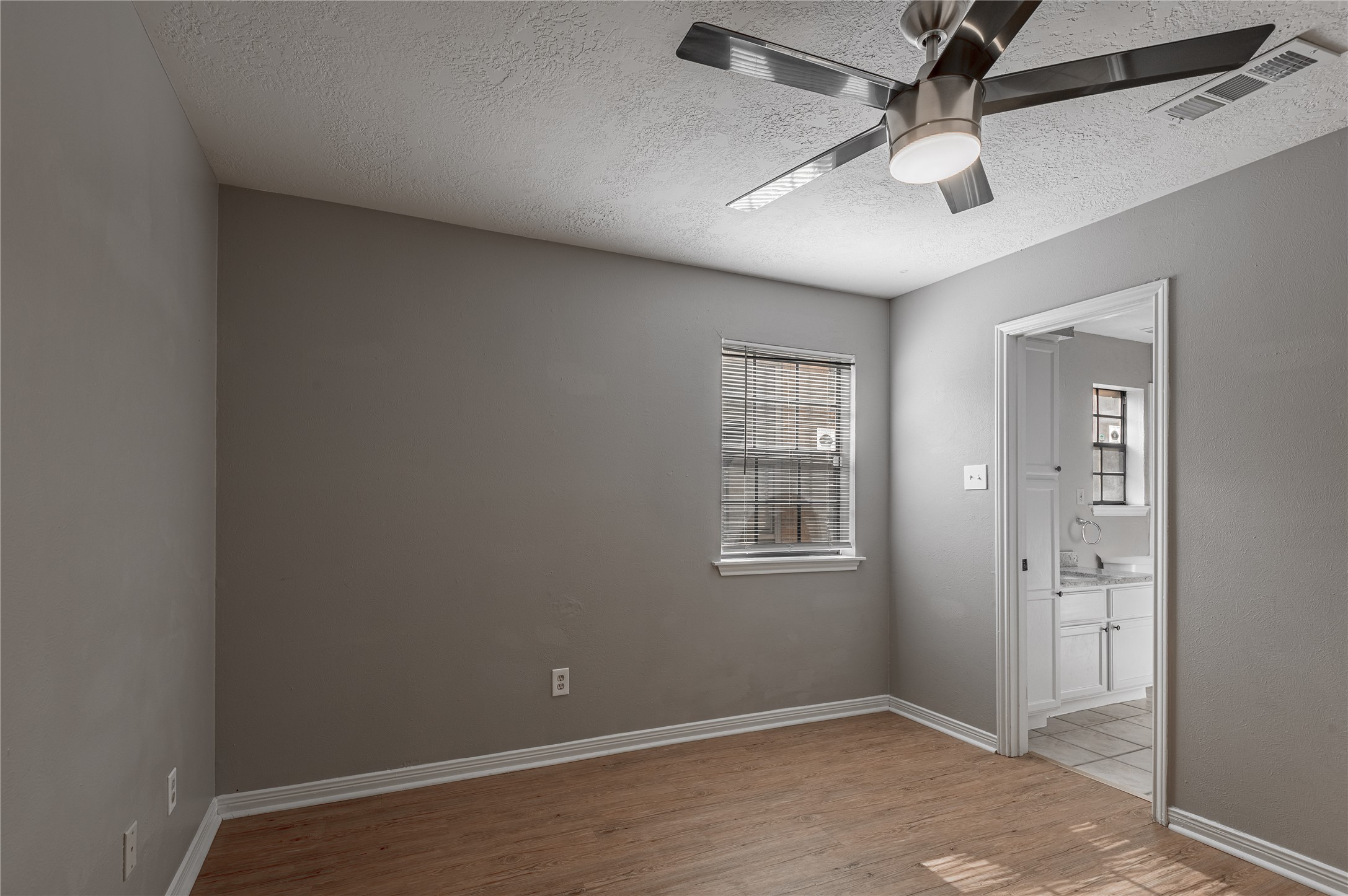 2402 Sycamore Avenue, Unit E2 Huntsville, TX 77340 - Photo 18 of 43 an empty room with windows and fan