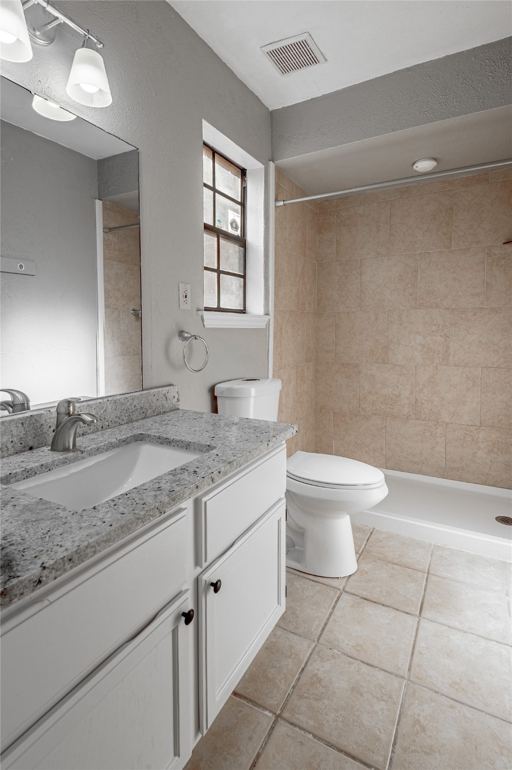 2402 Sycamore Avenue, Unit E2 Huntsville, TX 77340 - Photo 21 of 43 a bathroom with a granite countertop sink a toilet and a mirror