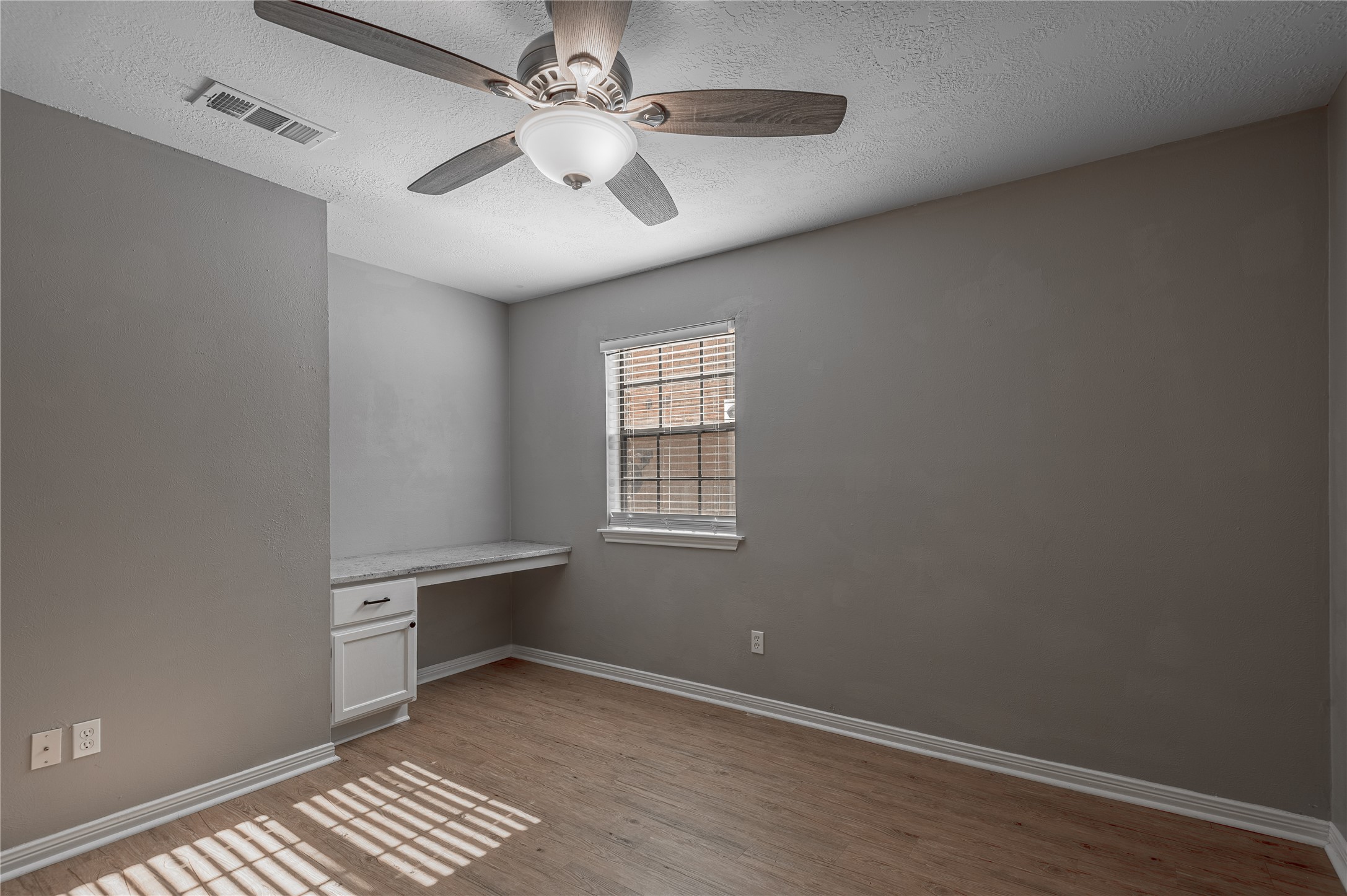 2402 Sycamore Avenue, Unit E2 Huntsville, TX 77340 - Photo 23 of 43 an empty room with windows and fan