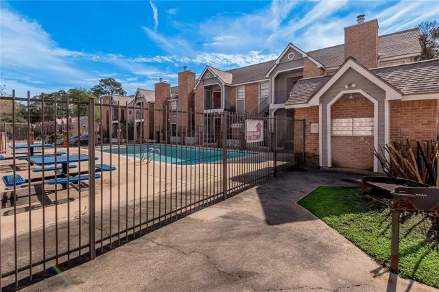a view of a brick house with iron fence