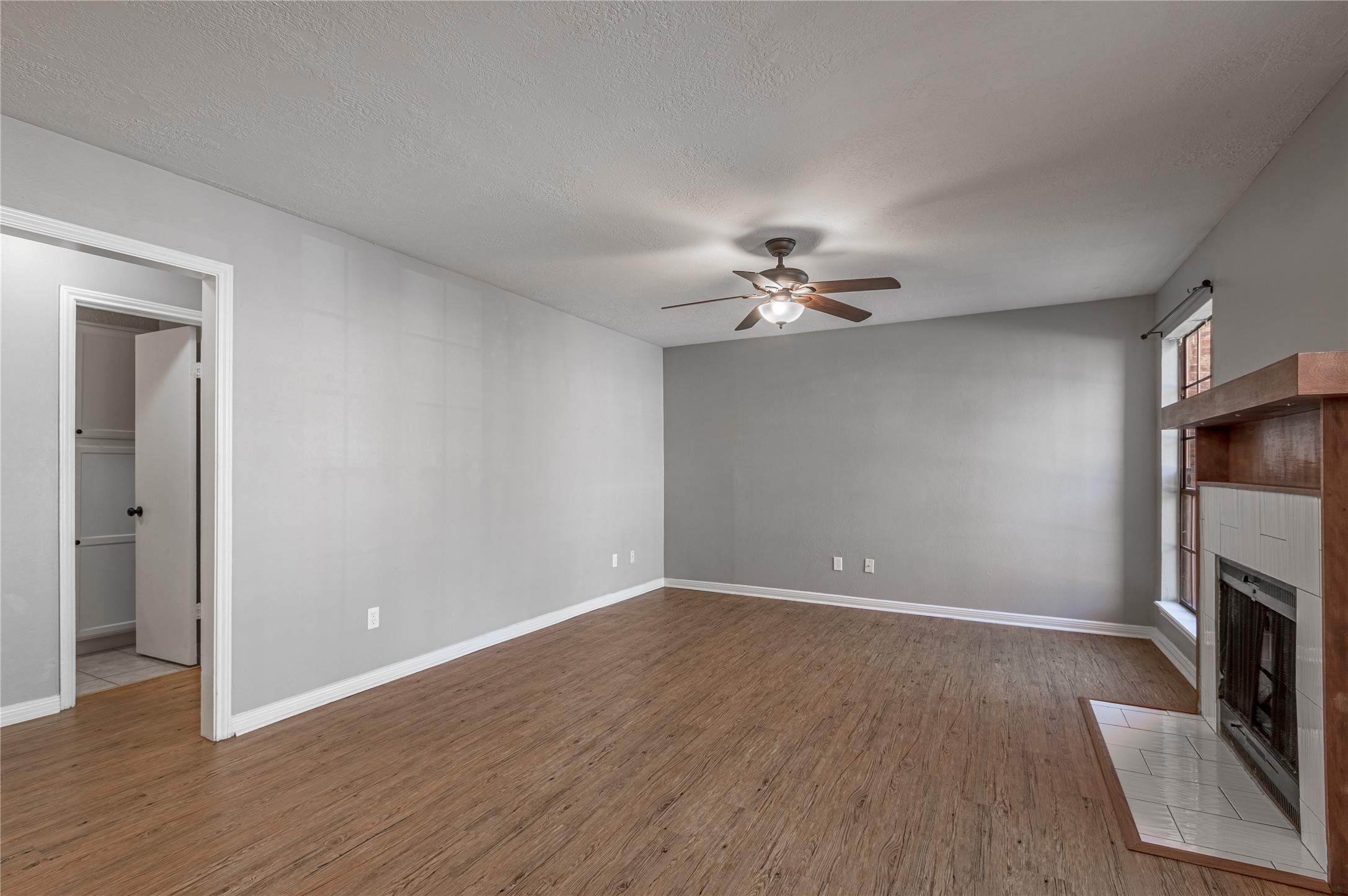 2402 Sycamore Avenue, Unit E2 Huntsville, TX 77340 - Photo 6 of 43 a view of an empty room with wooden floor and a fireplace