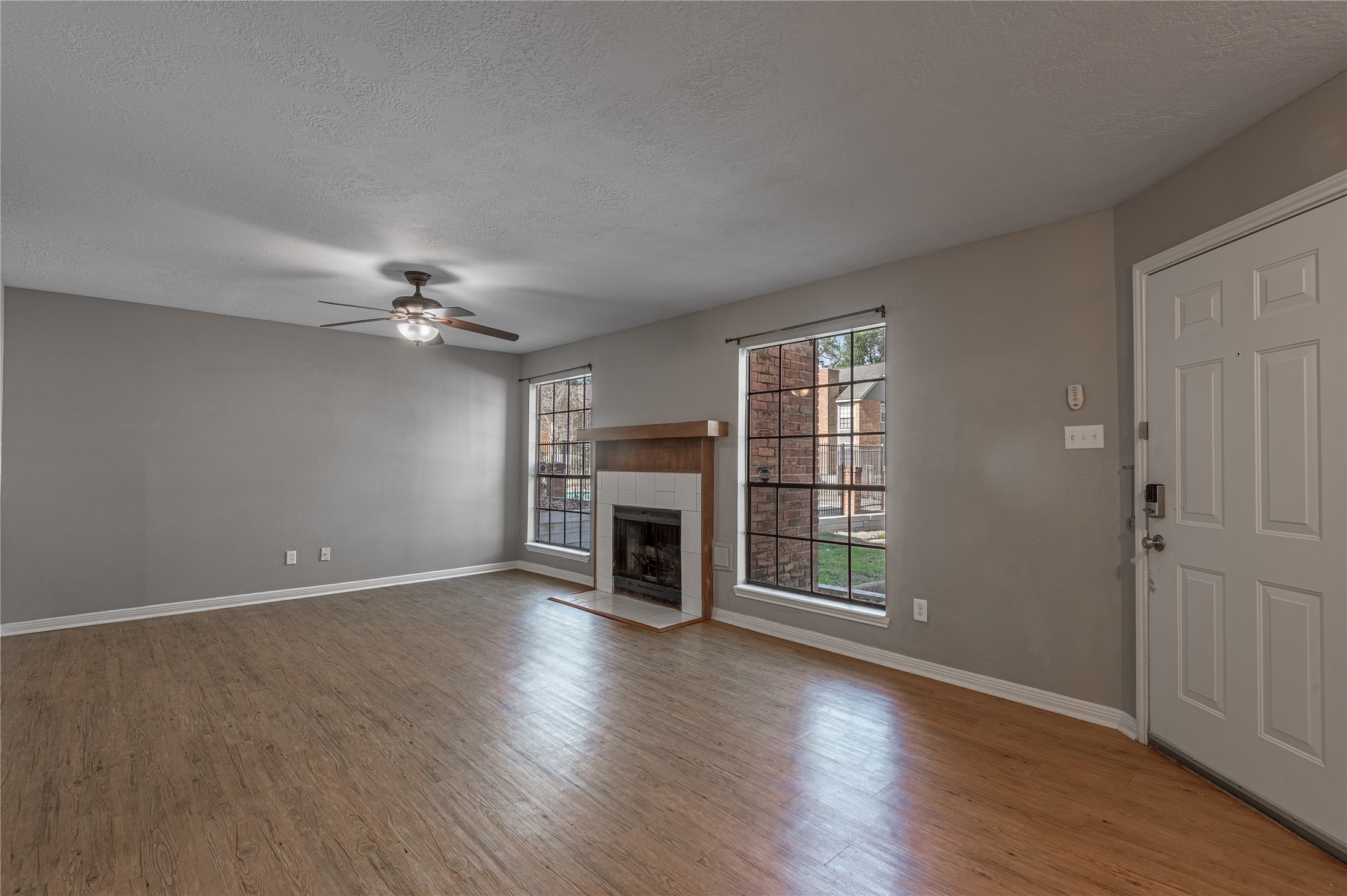 2402 Sycamore Avenue, Unit E2 Huntsville, TX 77340 - Photo 7 of 43 an empty room with fireplace wooden floor and windows