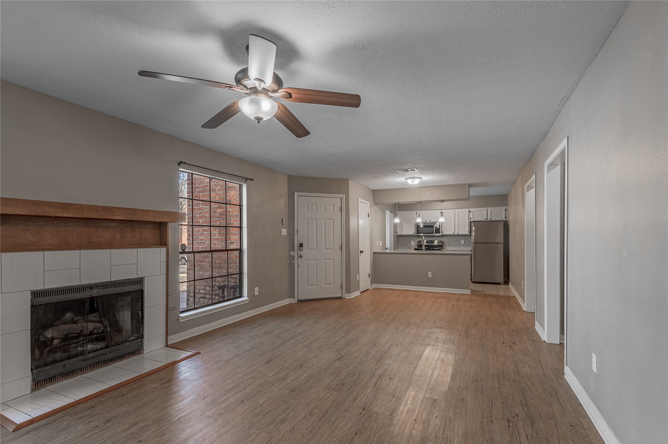 2402 Sycamore Avenue, Unit E2 Huntsville, TX 77340 - Photo 8 of 43 a view of a livingroom with a fireplace a ceiling fan and windows
