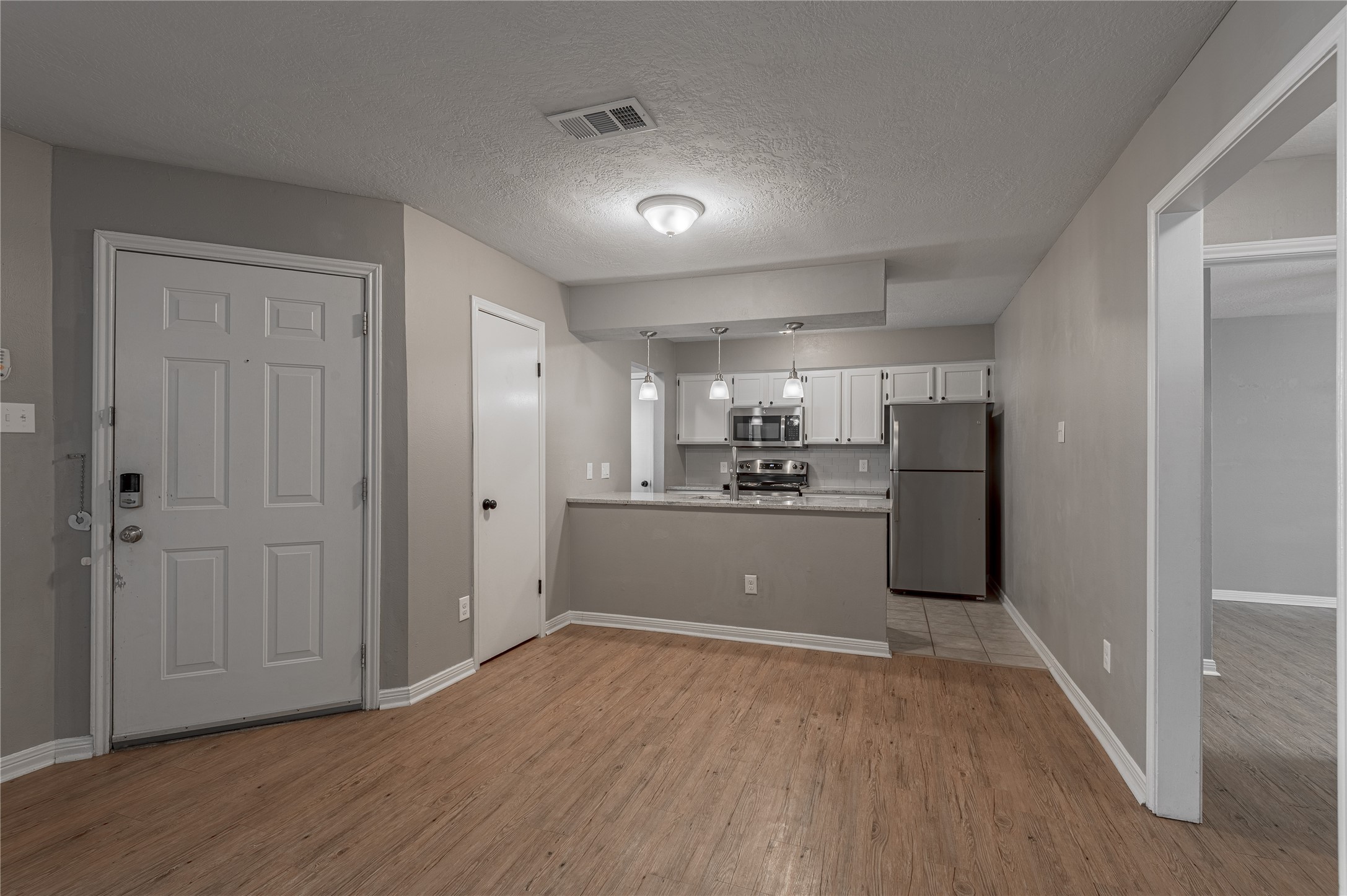 2402 Sycamore Avenue, Unit E2 Huntsville, TX 77340 - Photo 10 of 43 a view of large kitchen with refrigerator and wooden floor