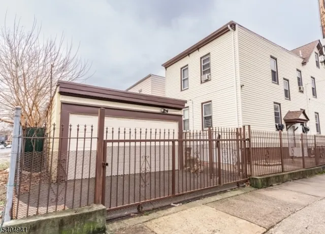 a front view of a house with iron fence