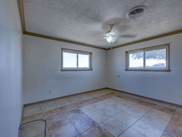 a view of an empty room with a chandelier fan