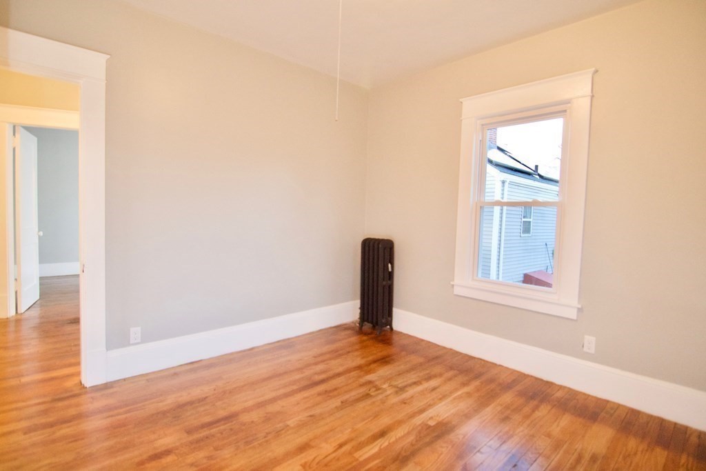 81 Haskin Street Springfield, MA 01109 - Photo 29 of 39 an empty room with wooden floor and a window