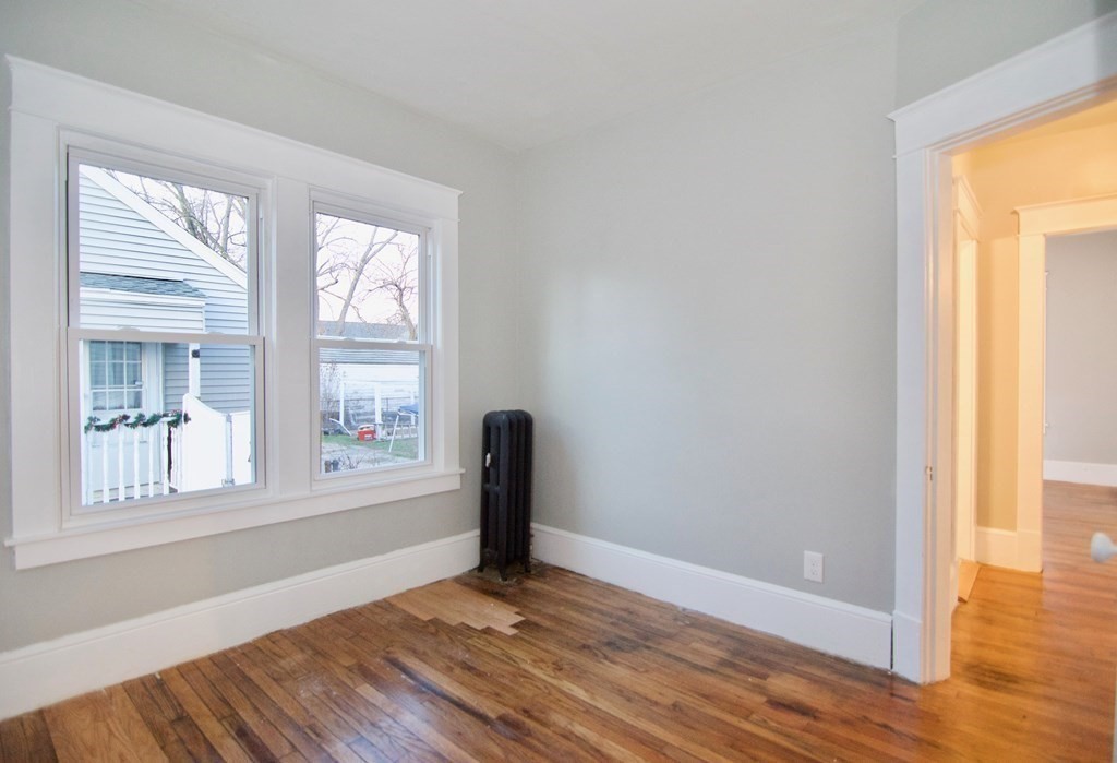 81 Haskin Street Springfield, MA 01109 - Photo 32 of 39 a view of an empty room with wooden floor and a window