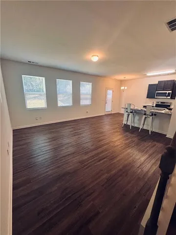 a view of a room with wooden floor lounge chair and windows