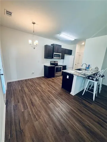 an open kitchen with kitchen island and stainless steel appliances