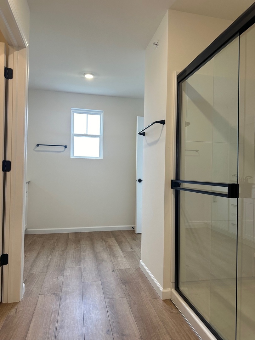 5949 Hawkweed Drive Plainfield, IL 60585 - Photo 16 of 25 an empty room with wooden floor and a glass door