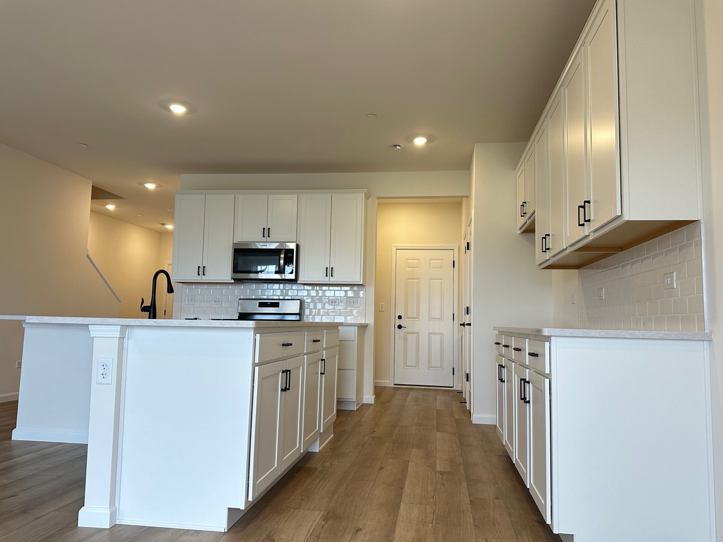 5949 Hawkweed Drive Plainfield, IL 60585 - Photo 4 of 25 a kitchen with stainless steel appliances granite countertop a refrigerator a sink dishwasher a stove and white countertops with wooden floor
