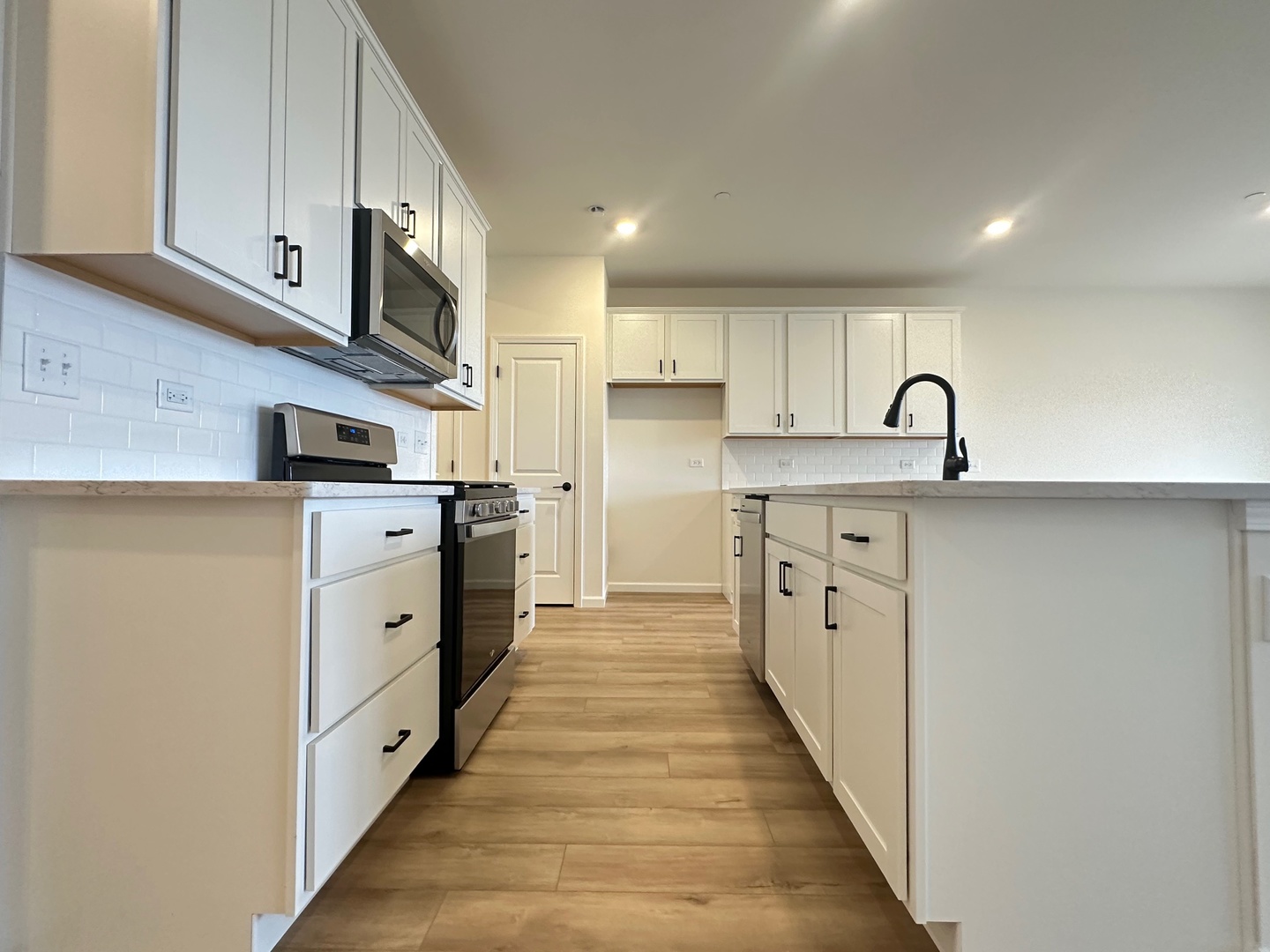 5949 Hawkweed Drive Plainfield, IL 60585 - Photo 6 of 25 a kitchen with stainless steel appliances granite countertop a stove a sink and a refrigerator