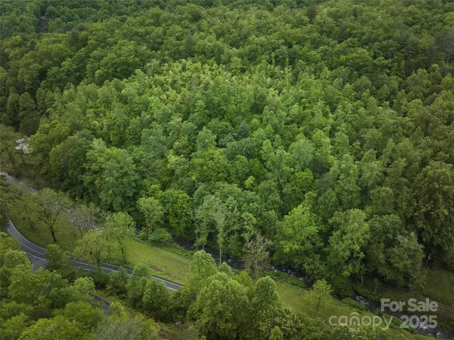 an aerial view of residential house with outdoor space and trees all around