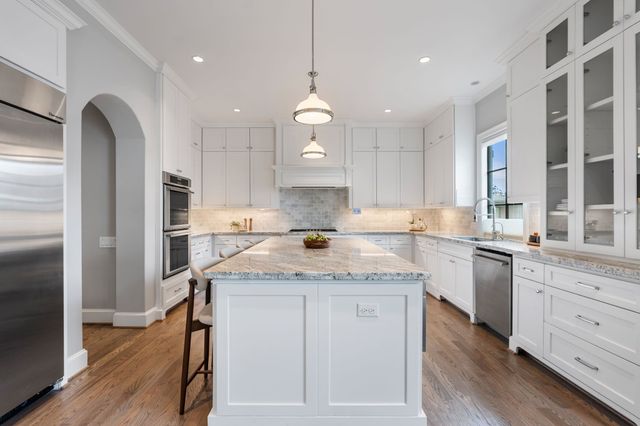 a kitchen with a refrigerator sink and cabinets