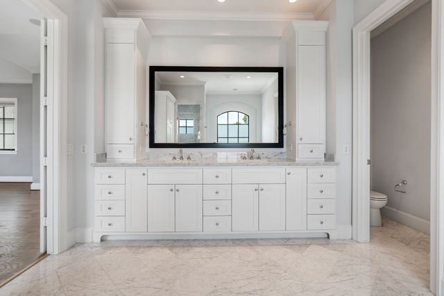 a view of a toilet storage cabinet and a vanity