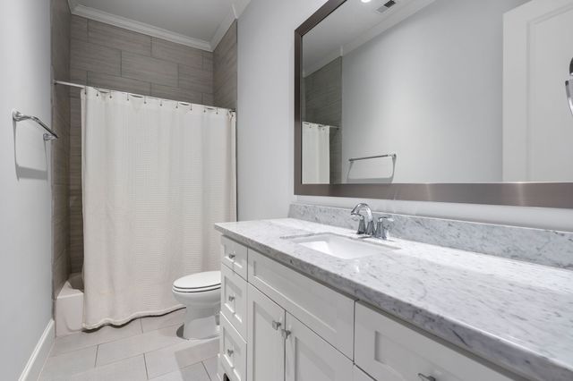 a bathroom with a granite countertop sink a toilet and a mirror