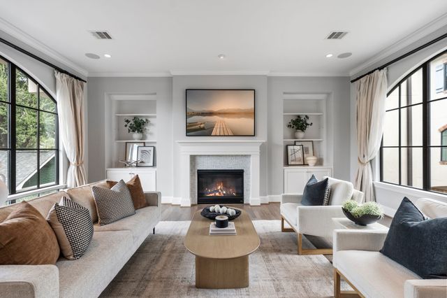 a living room with furniture a fireplace and a floor to ceiling window