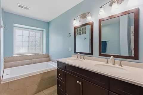 a bathroom with a tub sink and mirror