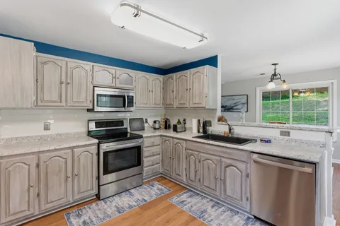 a kitchen with granite countertop white cabinets and white appliances