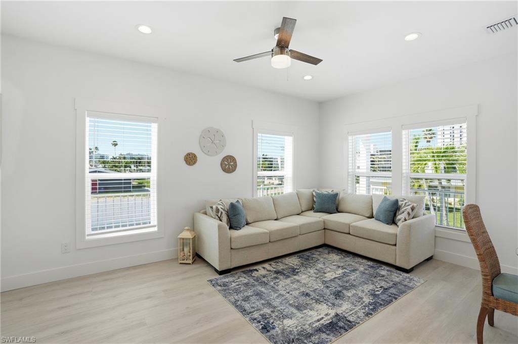 1 Fairview Boulevard Fort Myers Beach, FL 33931 - Photo 8 of 48 Bright interior space featuring light wood-finish flooring, recessed lighting, and a ceiling fan with light fixture - Virtually Edited Image