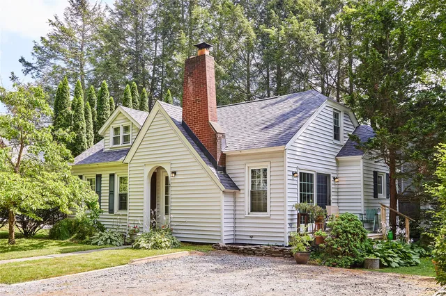 a view of a house with a yard and large tree