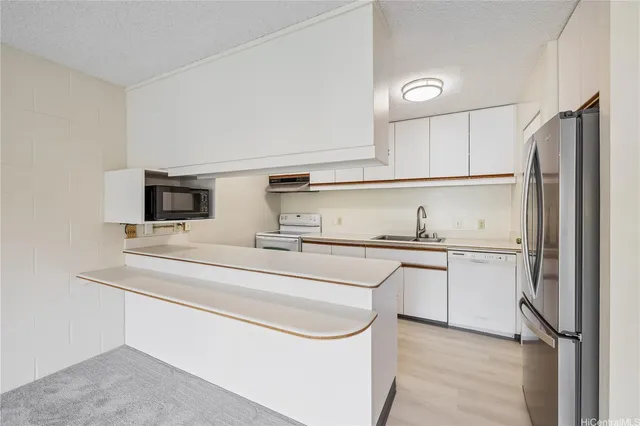a kitchen with stainless steel appliances white cabinets and a refrigerator