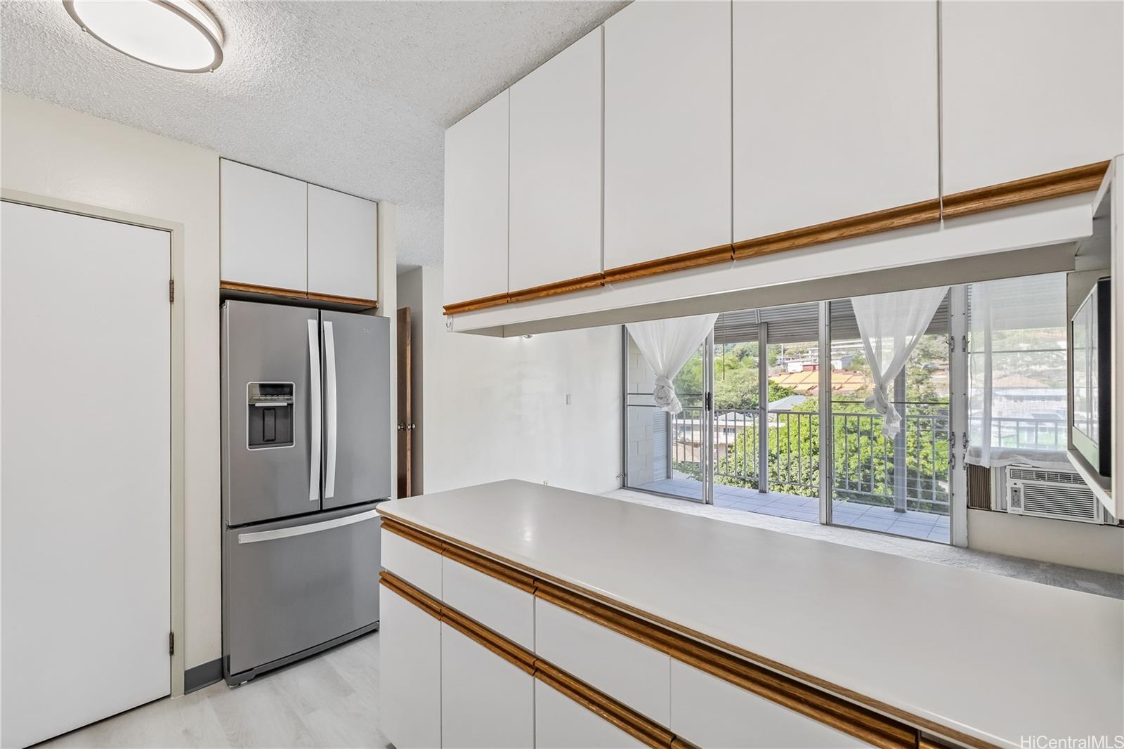 1687 Pensacola Street, Unit 804 Honolulu, HI 96822 - Photo 8 of 22 a kitchen with windows and refrigerator