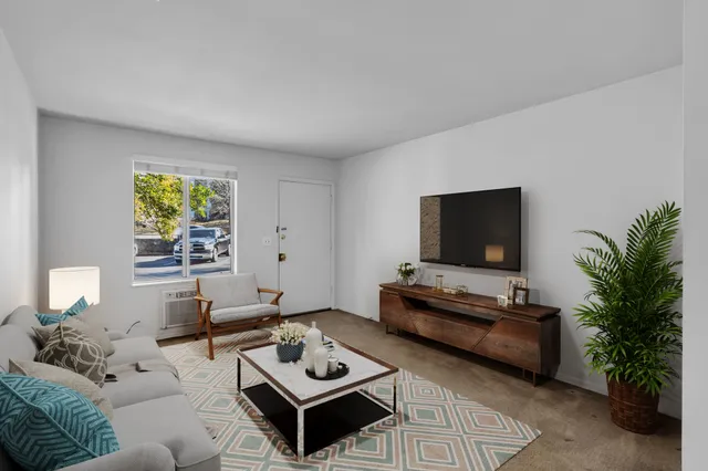 a living room with furniture a window and a flat screen tv