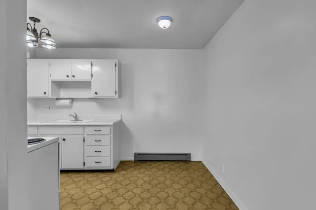 a kitchen with granite countertop white cabinets and white appliances
