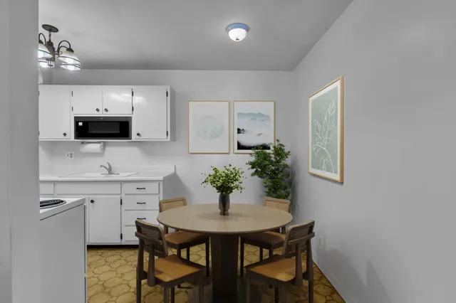 a kitchen with table and chairs in it