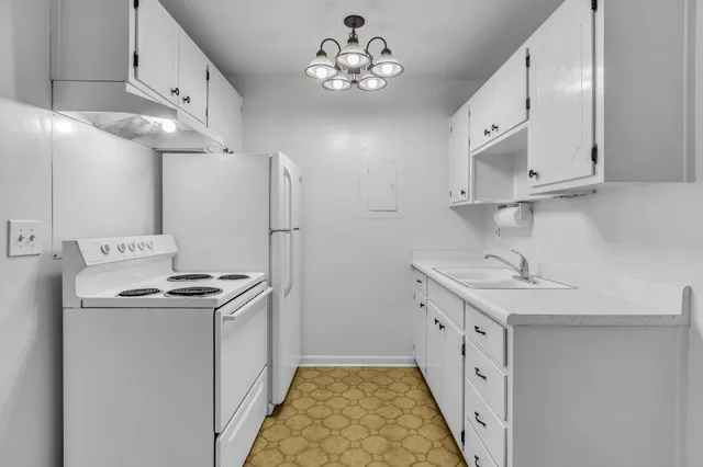 a kitchen that has a sink a stove and a refrigerator