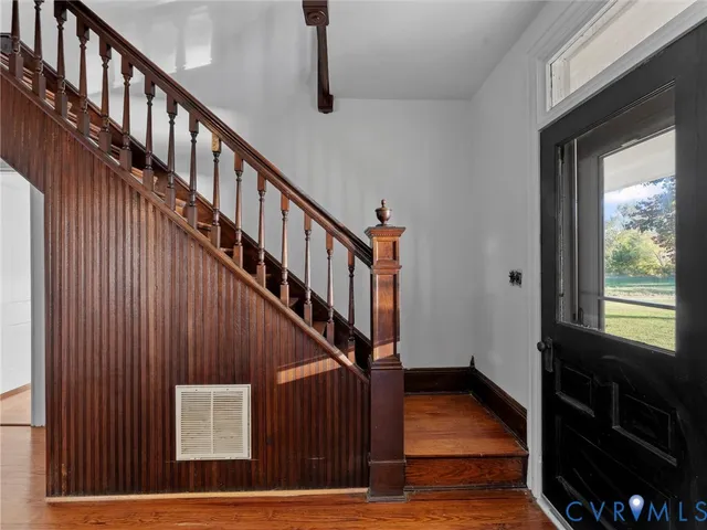 a kitchen with granite countertop wooden floors a stove and a refrigerator