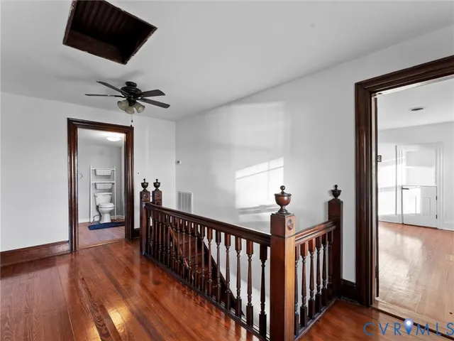 a view of a room with wooden floor and a ceiling fan